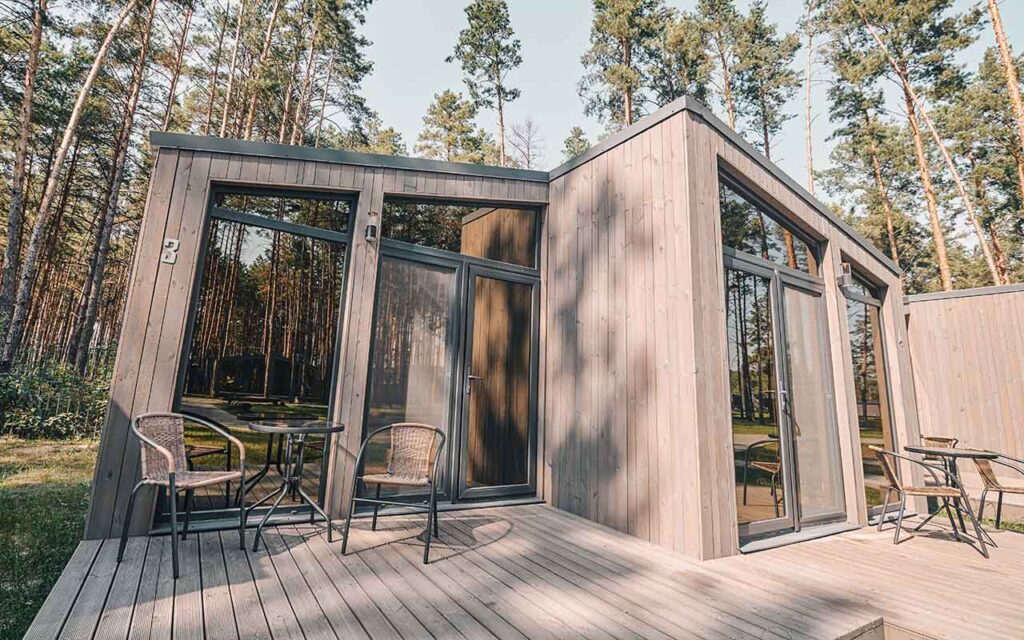 cadru aratand o casa moderna de vacanta in padure conecatata la o fosa septica